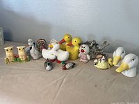 Full lot of various vintage bird-themed salt and pepper shakers on neutral cloth.