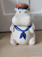Front view of the ceramic hippo cookie jar dressed in sailor outfit, showing facial details and blue neckerchief.
