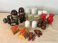 Front angle showing full variety of vintage salt and pepper shakers on table surface.