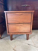 Front view of walnut nightstand showing two drawers and tapered legs