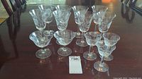 Set of 12 stemmed crystal glasses showing two styles on a table with inventory tag