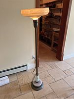 Full view of the antique floor lamp with its distinct patterned glass shade and metal base.