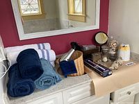 Full view of all items spread across bathroom vanity. Includes bath towels, hair dryer, decorative items and Conair light wand box.