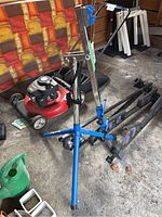 Blue bicycle repair tripod stand with adjustable height and securing hooks