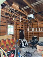 Garage interior showing ceiling space with toboggans, skis, and tricycle below.