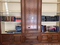 Wide shot of four shelves with various books including encyclopedia, history, and classic literature