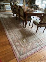 Full view of the wool carpet under dining table showing overall pattern, border, and dimensions in room context