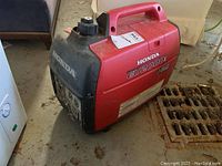 Front-left angle view of generator showing red and black housing and integrated handle