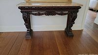 Front view of hall table showing marble top and carved wood base