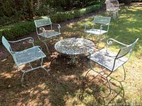 Group shot of round metal table and four chairs arranged outdoors