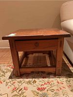 Front view of the side table on a patterned rug showing full piece