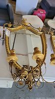Front view of entire mirror and attached two-arm candelabra