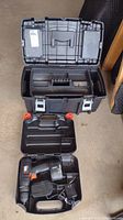 Photo showing open Husky toolbox, inner compartments and the Black & Decker cordless drill with attached battery and charger inside the bottom compartment.