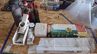 Lot overview on wooden table showing blinds, airpot, kitchen bottles, Salad Shooter, and other items.