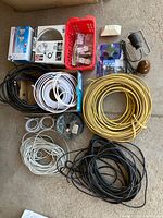 Overview photo showing various rolls of cables, lamp, insulator, and plug adapters arranged on the floor