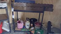 Full view of one metal shelving unit loaded with various garden and household items, illustrating size and structure.