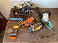 Black & Decker electric tools, small hand tools, and parts on wooden table