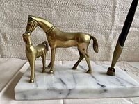 Close-up of brass horses and fountain pen on marble base showing details and condition