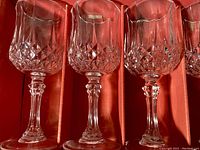 Close-up of three crystal wine glasses side-by-side showcasing intricate diamond cut pattern and decorative stems.