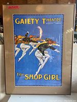 Full view of the framed vintage theatre poster 'The Shop Girl' with Gaiety Theatre title, colors, and matting under glass.