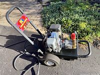 Portable pressure washer unit with Honda engine and pump on two-wheeled frame