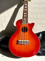 Front close-up photo of the Mahalo flame color ukulele body and part of the neck, showing the gradient finish and strings.