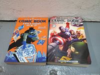 Front covers of the two Overstreet comic book price guides, 2010-2011 edition on the left with Batman and Joker artwork, 2015-2016 edition on right with Captain America and others.