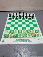 Full chess board laid out with all pieces in starting position, showing Canadian Chess Federation branding and green and white squared design.
