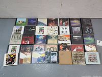 Overview photo showing 33 CDs arranged flat on floor, CD cover art visible for identification; lot includes Led Zeppelin and Pink Floyd albums.