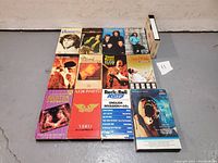 Front view showing 13 classic rock VHS tapes with cover artwork from artists including Jimi Hendrix, Led Zeppelin, The Doors and more.