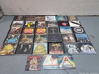 Top down view of all 34 CDs laid flat showing album covers with various metal and hard rock bands.