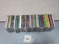 Overview photo of all 26 Sub Pop CDs arranged in a row with spines facing up showing titles and labels.