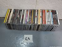 Photo of the full collection of 28 jewel case CDs arranged side by side showing spines and titles.