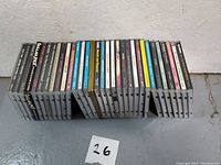 Photo showing full collection of 26 CDs arranged standing upright showing the spines against a wall.