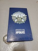 Blue box of The Police 'Message in a Box: The Complete Recordings' with metallic emblem on top.