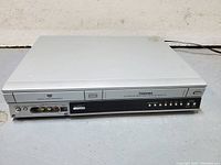 Front view of the Toshiba D-VR3 DVD VHS recorder showing input jacks, control buttons, and the VHS slot.
