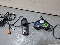 Two plug-and-play video game controllers on floor; one Atari Paddle controller and one third-party controller with AV cables.