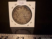 Front side of 1962 Canadian Silver Dollar coin showing Voyageur design with canoe and fur bundle, marked with 'CANADA DOLLAR 1962'.