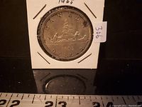 Front side of the 1965 Canadian silver dollar coin showing the canoe design and inscriptions.