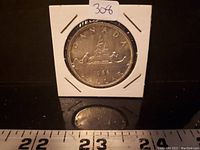 Obverse side of the 1966 Canadian silver dollar showing the canoe design, with 'CANADA' and '1966' inscriptions. Coin is in a protective cardboard holder.