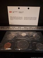 Close-up of sealed coins in original packaging with bilingual informational text.