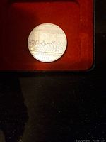 Photo of the silver-colored coin with the inscription 'Constitution 1932' visible, showing the engraved image of a historic scene.