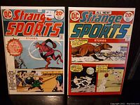 Two DC Strange Sports comic books, issue #1 on left with a devil character on cover, issue #2 on right with dinosaur and unusual sports scenes on cover.