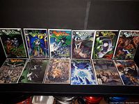 Photo showing a selection of The Spectre comic book issues laid out in two rows on a black surface with varied cover art including characters in dramatic poses and eerie supernatural settings.