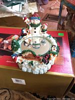 Musical skater snowman figurine with mirror base labeled North Pole, featuring small winter characters