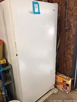 Full front view of the closed Kenmore freezer showing rectangular body with handle on left side and a blue label on the top.