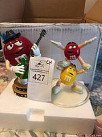 Photo of two M&M figurines - Red with guitar and dual Red/Yellow gymnastics pose