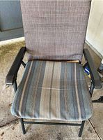 Front view of one collapsible lawn chair showing cushioned striped seat and textured gray fabric backrest