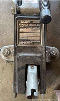 Close-up of Sears Hydraulic Service Jack model and capacity label