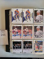 Front view of binder open showcasing 9 hockey cards per page on a black binder spine. Cards mostly feature Wayne Gretzky in Edmonton Oilers and Los Angeles Kings uniforms.